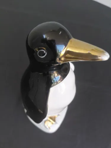 Pinguim de geladeira antigo de porcelana com bico e patas dourados