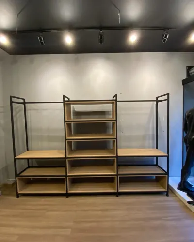 Estante estilo industrial com araras de roupas