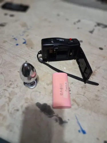 Maquina fotográfica carregador e um objetos de infeite metálico