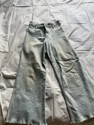 Calça jeans clara desfiada na ponta