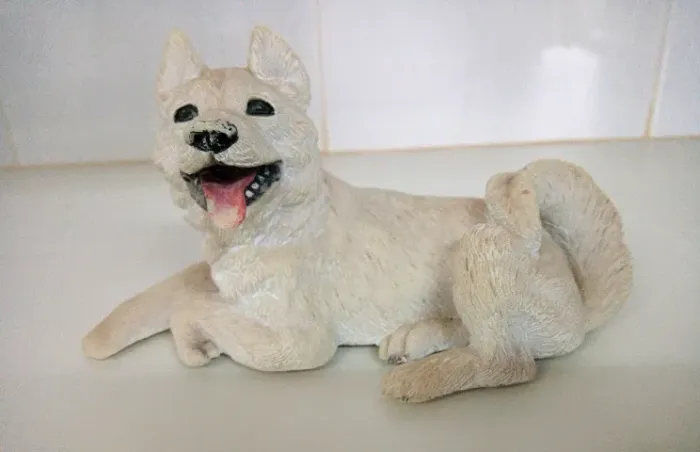 Escultura de Cachorro em resina. Tamanho comp. 17 x Alt. 9 cm.