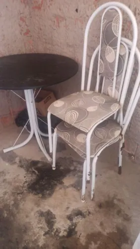 Mesa e cadeiras com marcas de uso.