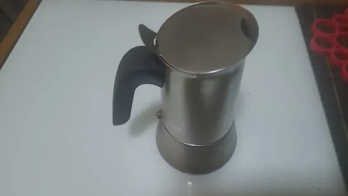 cafeteira italiana Moka tradicional feita de aço inoxidável com cabo preto.