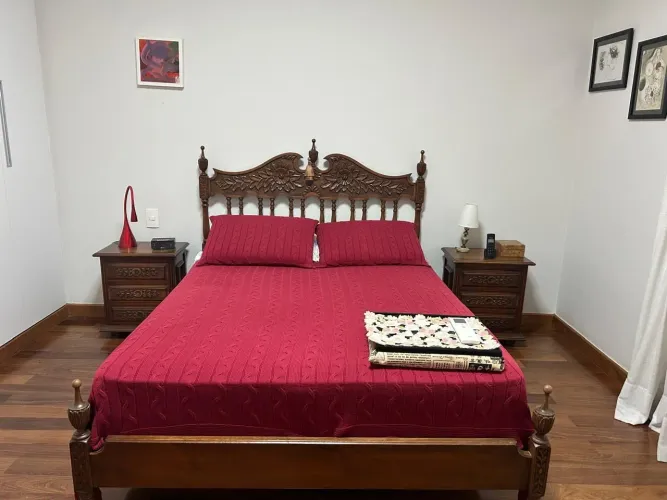 Cama de casal com 2 mesas de cabeceira.