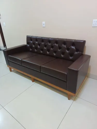 Sofá de couro sintético, com base exposta de madeira maciça, espuma d33