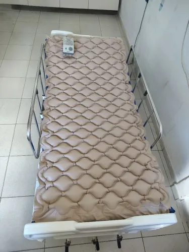 Cama articulada, cadeira de rodas e almofadas para facilitar o rolamento