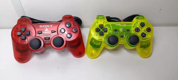 controle playstation 2 translúcidos, vermelho e amarelo