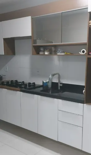 Pia cozinha de pedra com cuba inox e torneira gourmet.