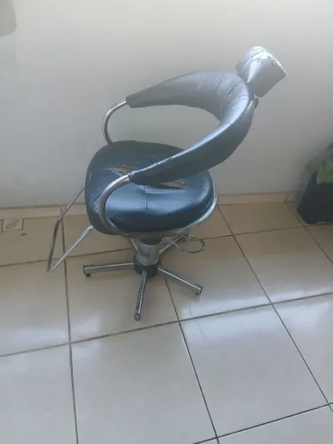 Cadeira de salão com marcas de uso funcionando perfeitamente.