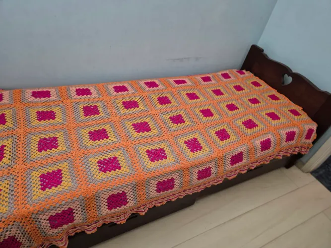 Duas colchas iguais de croché coloridas para camas de solteiro.