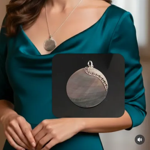 Pingente grande em madrepérola natural com detalhe em prata.