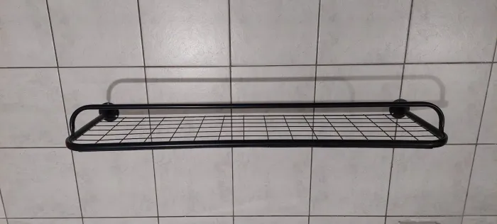 Arara de roupas preta em metal de pendurar na parede com prateleira