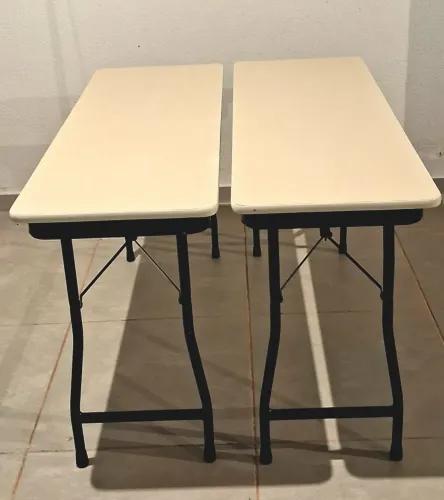 Mesa retangular com pés dobráveis.