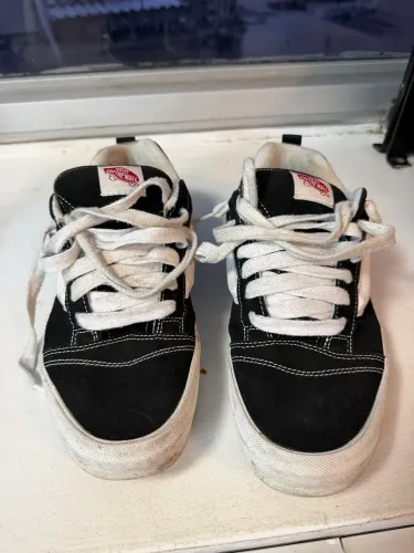 Vans Knu Skool preto e branco com cadarços brancos.