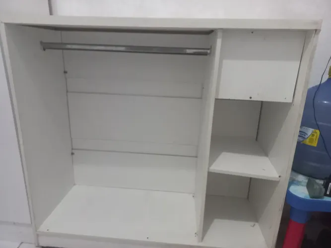Balcao de atendimento para loja de roupas com gaveta atras e arara na frente.