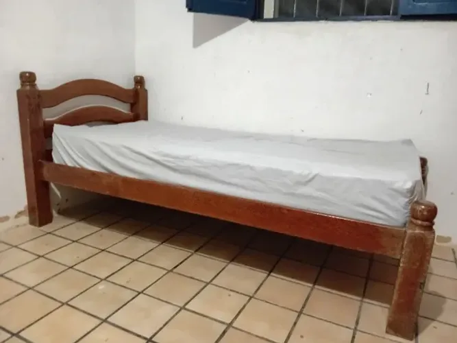 Cama de solteiro de madeira maciça.