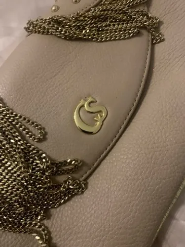 Bolsa Clutch da marca Carmen Steffens em couro na cor bege com correntes douradas 