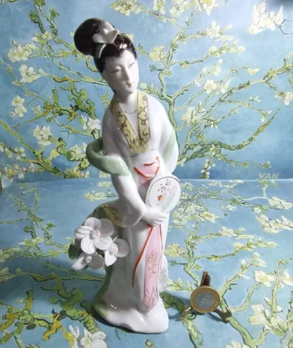 Escultura feita de porcelana, de origem oriental, representando gueixa, altura 24cm. Nova 