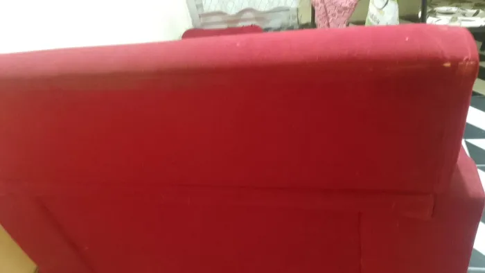Um sofá de dois lugares na cor vermelho