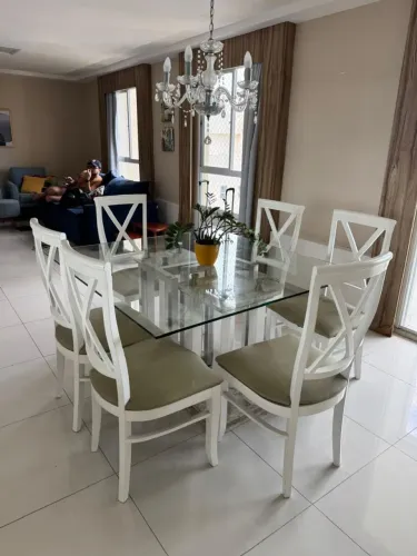 Mesa com 6 cadeiras, aparador, lustre.