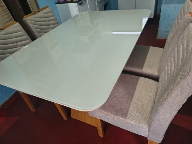 Mesa com base de madeira e em cima de vidro com 4 cadeiras confortáveis
