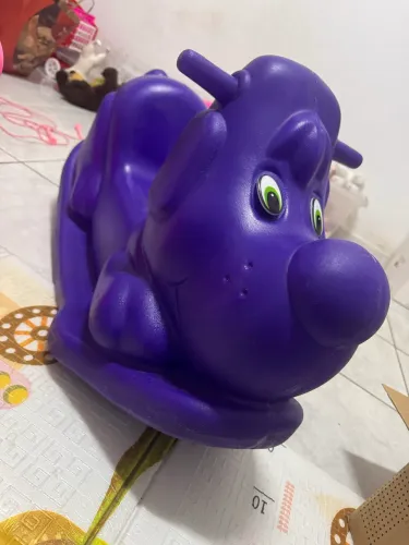 gangorra infantil de plástico rosa no formato de um cachorro