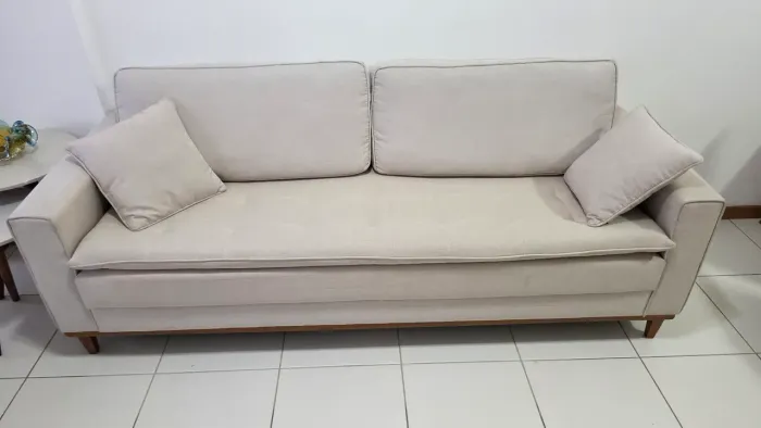 Vendo lindo sofá de 3 lugares, na cor bege/off-white, com design elegante e atemporal.