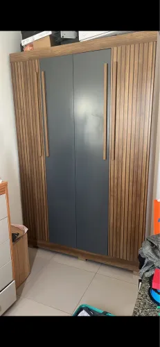 guarda-roupa de MDF com acabamento ripado/amadeirado e portas centrais cinza
