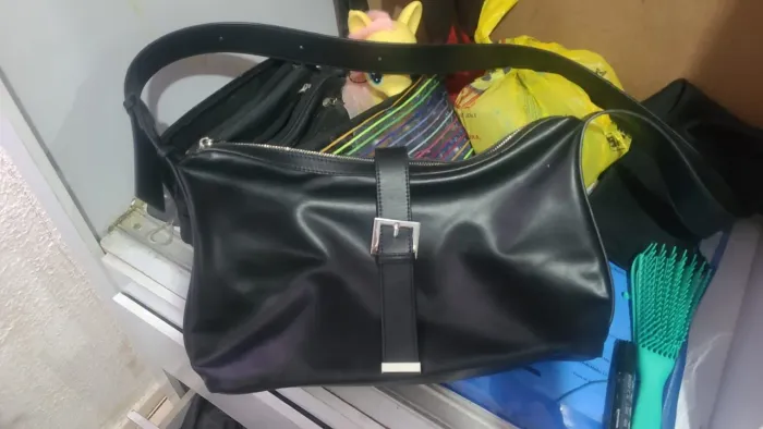 bolsa de ombro preta modelo Hobo com alça longa e fechamento por fivela