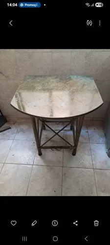 Mesa com tampo de granito e pé em ferro trabalhado.