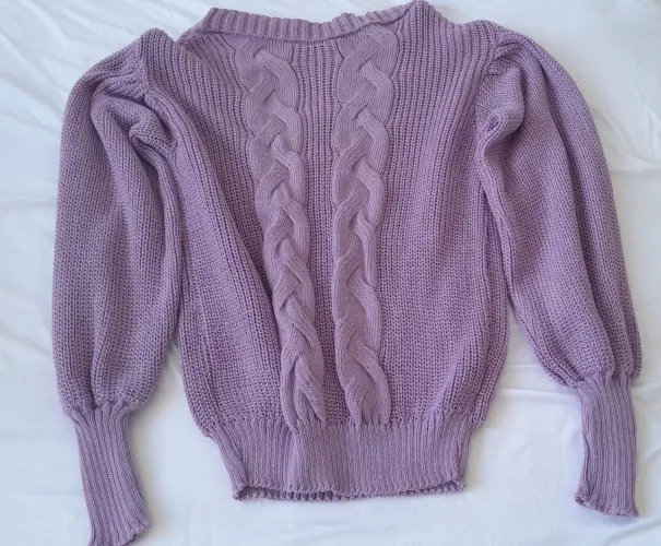 Suéter roxo com detalhes em tranças e mangas.