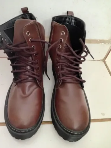 Bota coturno marrom de cano médio com solado tratorado estilo plataforma. <br>