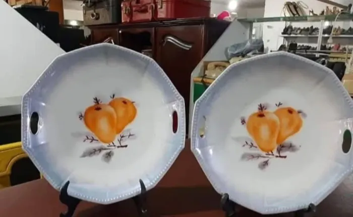 VENDO 2 PRATOS DE DECORAÇÃO EM PORCELANA CONTENDO PEGADOR VAZADO E DESENHOS DE FRUTAS. 